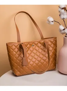 Détail du cabas matelassé marron montrant la couture et le fermoir magnétique