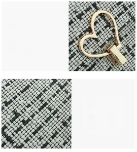 Detail of light gold heart-shaped twist lock on black and white tweed canvas handbag