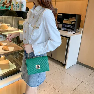 Green V-quilted women's crossbody bag with gold chain strap and clover twist lock