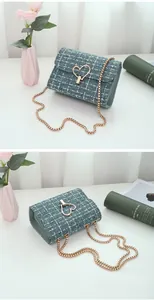 Detail of teal and white tweed bag with golden heart buckle and chain strap