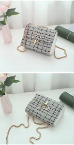 Detail of tweed crossbody bag with golden heart-shaped lock and chain strap
