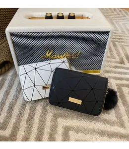 Dettaglio di mini portafogli geometrici in bianco e nero con finiture dorate