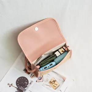 Straw and pink leather crossbody bag with magnetic closure and spacious interior storage
