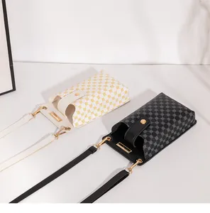 Details kleiner Umhängetaschen in Schwarz und Weiß mit geometrischen Mustern und Golddekor