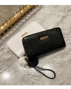 Detail of crocodile texture long wallets with fur ball charms and golden zippers