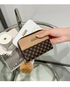 Κοντινό πλάνο μίνι γυναικείων πορτοφολιών με φλοράλ σχέδια και γούνινα μπρελόκ