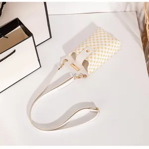 Detailansicht der weißen Handytasche mit gelbem Muster und goldener Metallschnalle