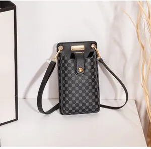 Detailaufnahme der schwarzen Handy-Umhängetasche mit goldenem Verschluss und Mustern