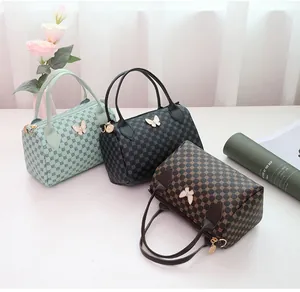 Three patterned Boston bags in green, black, and brown with butterfly charm detail