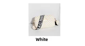 Détail du sac blanc avec motif à carreaux orange et bandoulière large noire