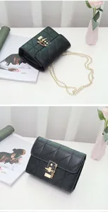 Detailed close-up of quilted black leather chain bag with golden square lock and metal strap