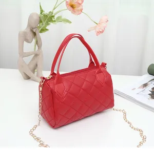 Close-up of red quilted handbag with gold chain strap and elegant texture detail