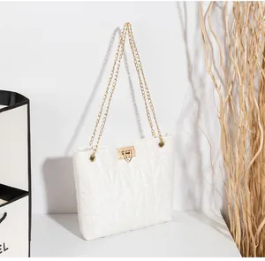 Detail of white geometric quilted bag with gold twist lock and fine chain strap