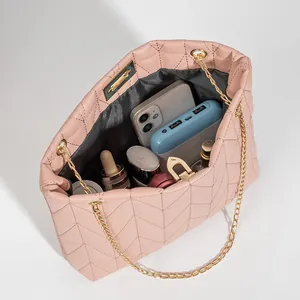 Pink quilted bucket bag with gold chain showing interior storage for cosmetics