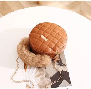 Vue détaillée du sac rond matelassé avec poignée en peluche et bandoulière dorée