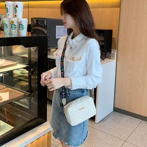 Elegant white crossbody camera bag with V-quilted faux leather and colorful LOVE strap