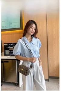 Gros plan du sac bandoulière marron à motifs avec une sangle textile large et tendance