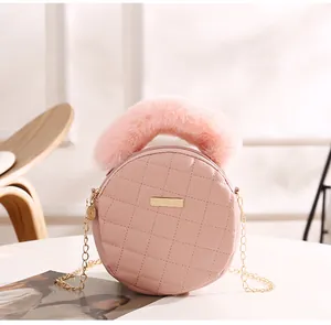 Vue détaillée du sac rond matelassé rose avec poignée en fausse fourrure et chaîne