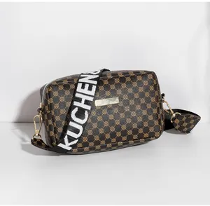 Détail du petit sac bandoulière avec motifs cercles et bandoulière large lettrée amovible