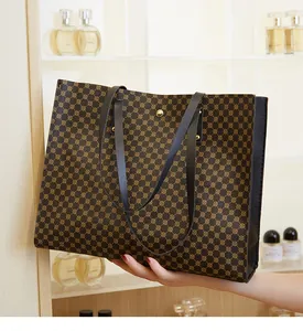 Detail of large tote bag featuring brown geometric circular patterns and gold metal buckle