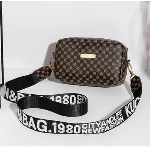 Détail d'un sac à bandoulière marron avec motifs circulaires et large sangle nylon