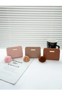 Trois modèles de portefeuilles courts pour femmes en rose, kaki et marron avec pompons doux
