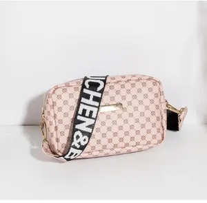 Vue détaillée du petit sac rose imprimé avec large bandoulière tissée et accessoires dorés