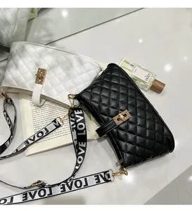 Dettaglio di borse in pelle trapuntata con chiusura dorata e tracolla con scritta LOVE