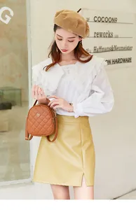 Brown quilted crossbody bag with golden clover logo shown in a street style outfit