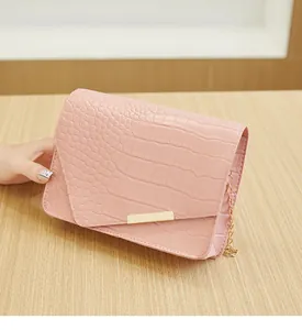 Vue détaillée du sac rose à motif croco avec bandoulière chaîne et rabat