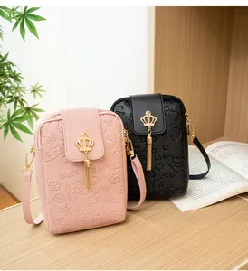 Detail of embossed mini phone bags with crown metal buckle and gold tassel accents