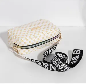 Gros plan d'un petit sac blanc à motif jaune avec sa bandoulière en nylon