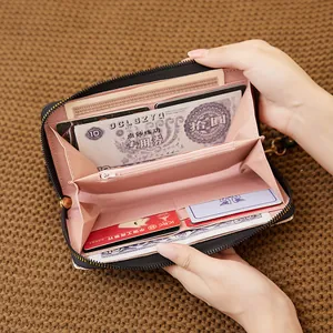 Women's long leather zipper wallet featuring black exterior with pink multi-slot interior