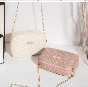 Détail des sacs à bandoulière vintage avec motifs géométriques et logos métalliques dorés