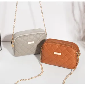 Détail des sacs bandoulière matelassés gris et marron avec trois poches zippées et chaîne