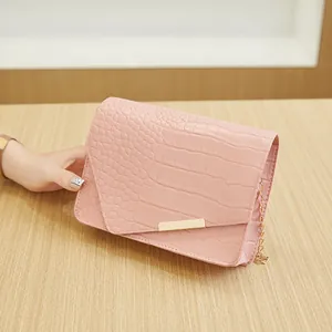 Sac bandoulière rose à motif crocodile avec chaîne dorée et rabat enveloppe