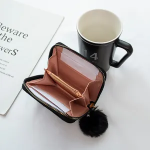 Portefeuille noir brodé avec pompon et fentes pour cartes à l'intérieur rose