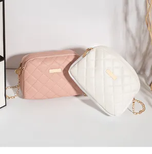 Détail de sacs bandoulière matelassés rose et blanc avec chaînes dorées élégantes