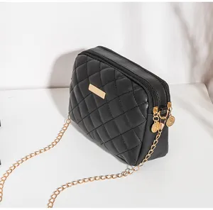 Détail du petit sac noir matelassé avec double fermeture éclair et bandoulière en chaîne