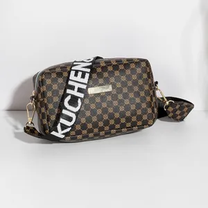 Brown monogram crossbody bag with wide black strap and gold hardware detail