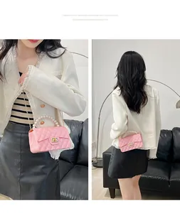 Detailed view of pink jelly crossbody bag with faux pearl handle and gold chain strap