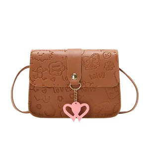 Brown embossed small crossbody bag with heart pendant and cute floral pattern details