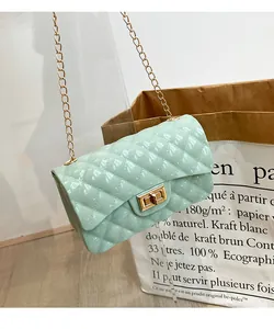 Detail view of mint green quilted jelly bag with gold metal twist lock and chain strap