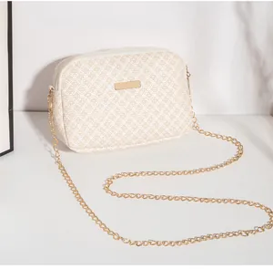 Détail du sac beige avec motifs floraux géométriques et plaque en métal doré de haute qualité