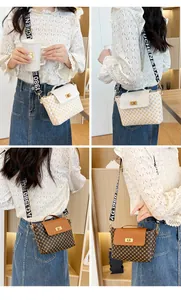 Detail view of quilted crossbody bag with designer letters wide strap and gold metal lock