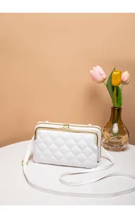 Dettaglio borsa a tracolla bianca trapuntata con accessori dorati e decorazione di tulipani