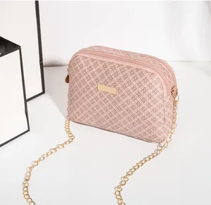 Détail du sac bandoulière matelassé rose avec double fermeture éclair et plaque dorée