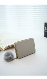 Detail of woven light gray leather wallet with gold zipper and gray pom-pom charm