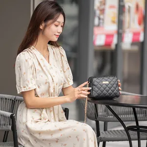 Sac bandoulière matelassé noir chic avec chaîne dorée et plaque métallique
