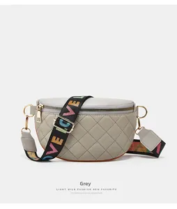 Close-up of quilted grey crossbody bag with rainbow LOVE strap and gold hardware